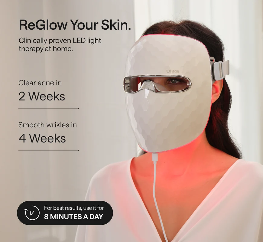 Woman wearing the Ulike ReGlow LED mask, showing its eye opening, side strap and controller cable